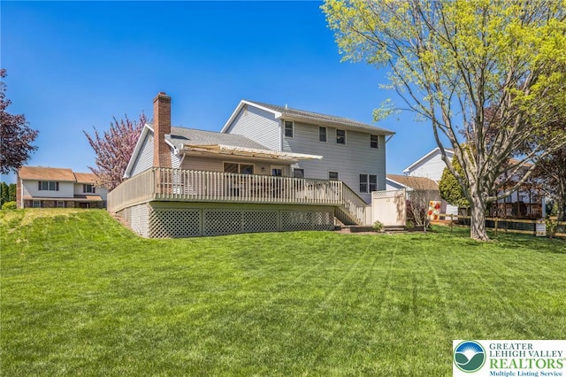 back of house with a lawn, stairway, a chimney, and a deck