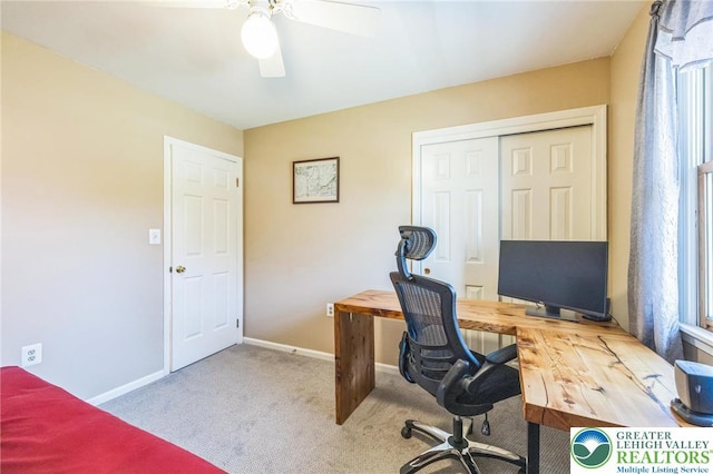 office space featuring carpet floors, a ceiling fan, and baseboards