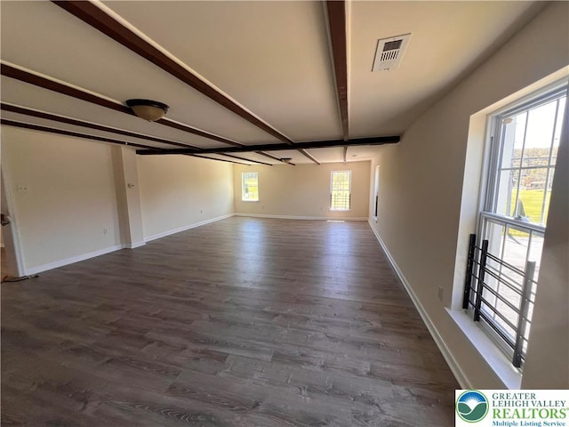 spare room with baseboards, visible vents, beam ceiling, and dark wood finished floors