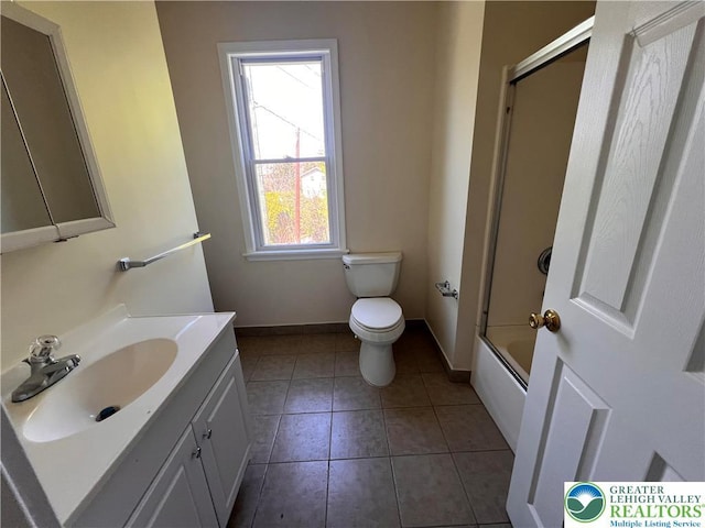 bathroom featuring shower / bath combination with glass door, vanity, toilet, tile patterned floors, and baseboards