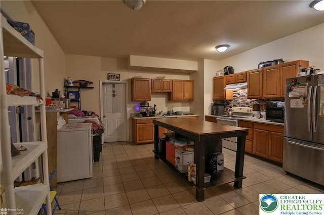 kitchen featuring light tile patterned flooring, black microwave, electric range oven, freestanding refrigerator, and under cabinet range hood