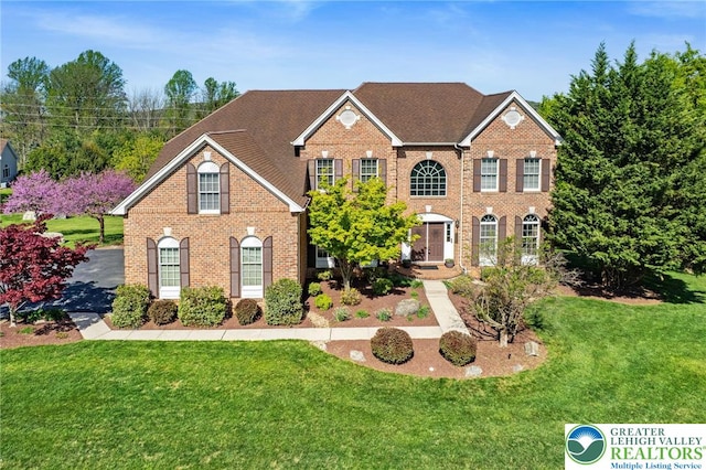 view of front of property with brick siding and a front yard