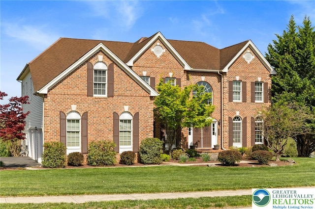 view of front of house featuring brick siding and a front yard