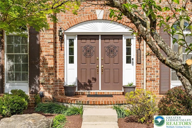property entrance featuring brick siding