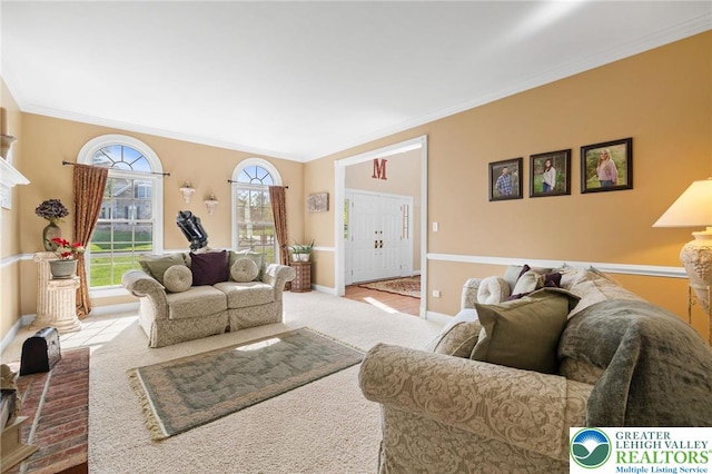 living room featuring carpet floors, baseboards, and crown molding