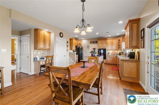 dining space featuring recessed lighting, baseboards, a notable chandelier, and light wood-style floors