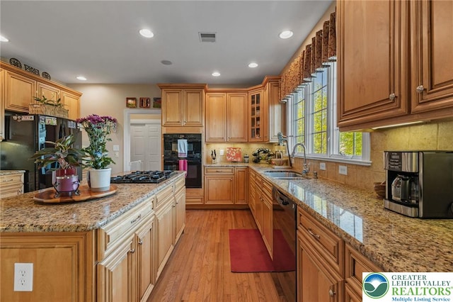 kitchen with visible vents, a sink, black appliances, light wood-style floors, and recessed lighting