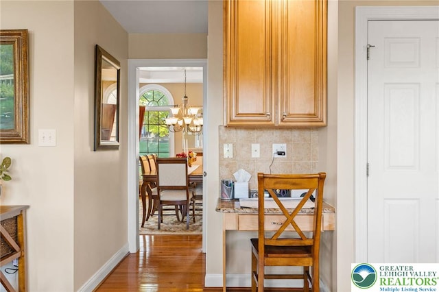 dining area with an inviting chandelier, baseboards, and wood finished floors