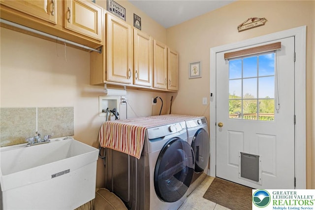 clothes washing area featuring a sink, separate washer and dryer, light tile patterned floors, and cabinet space