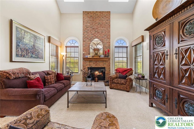 carpeted living room featuring a high ceiling and a fireplace