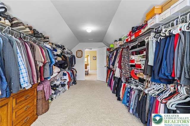 walk in closet with lofted ceiling and carpet
