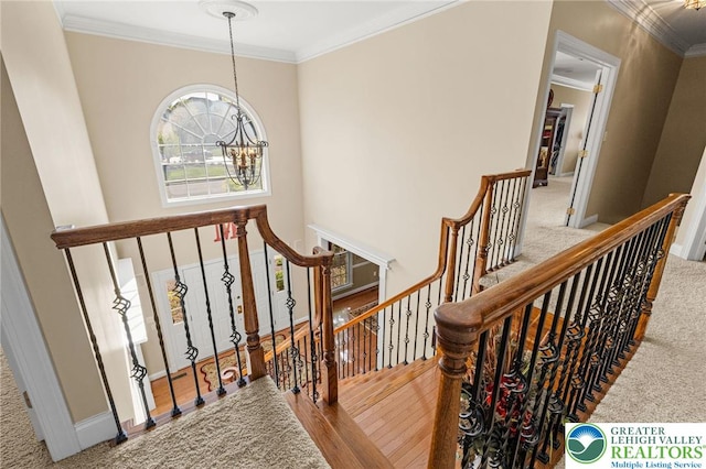 staircase with crown molding, baseboards, a chandelier, and carpet floors