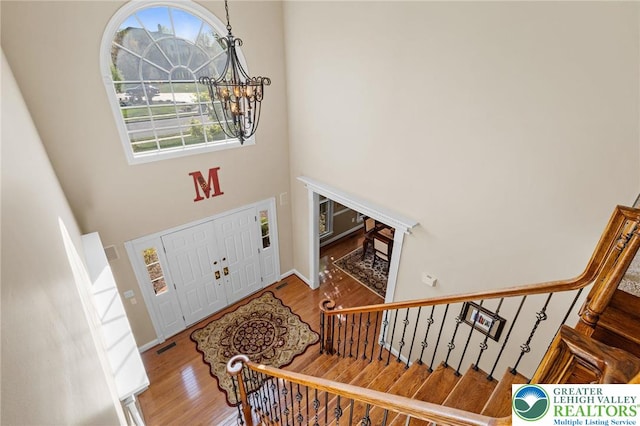 foyer with wood finished floors, a high ceiling, and a chandelier