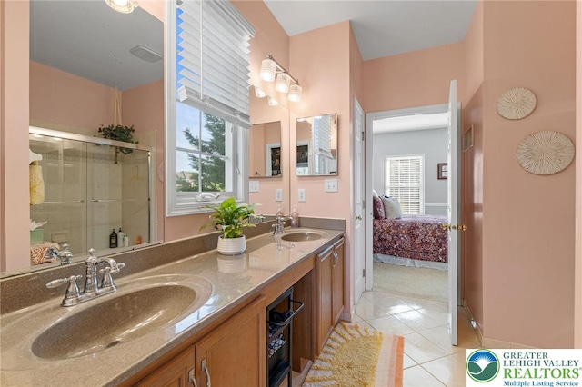 ensuite bathroom with a sink, connected bathroom, tile patterned floors, and a stall shower