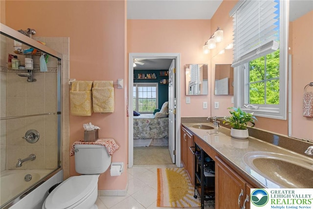full bath with shower / bath combination with glass door, a sink, tile patterned floors, and toilet