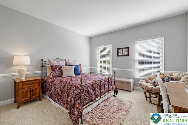 bedroom with baseboards and light colored carpet