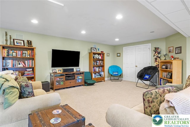 carpeted living area with recessed lighting and baseboards