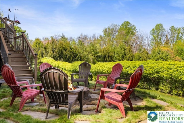 view of yard with stairs and an outdoor fire pit