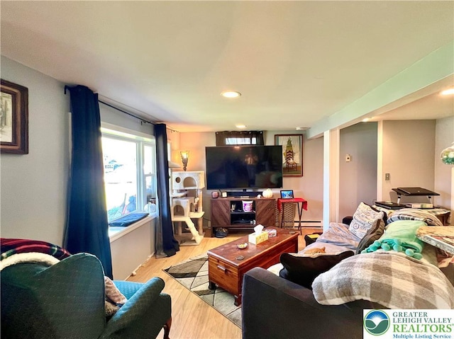 living area featuring recessed lighting, light wood finished floors, and a baseboard radiator