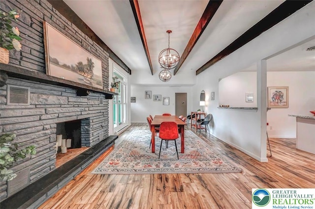 134 Altemose Rd, Tobyhanna Twp, PA 18347 - dining area with a stone fireplace, beam ceiling, wood finished floors, baseboards, and an inviting chandelier