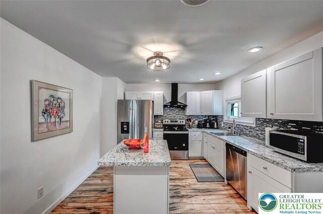 134 Altemose Rd, Tobyhanna Twp, PA 18347 - kitchen featuring wall chimney range hood, decorative backsplash, light wood-type flooring, a sink, and stainless steel appliances