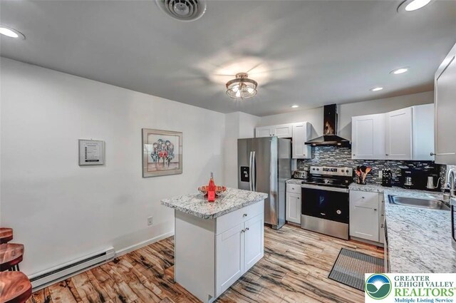 134 Altemose Rd, Tobyhanna Twp, PA 18347 - kitchen featuring baseboard heating, a sink, light wood-style floors, stainless steel appliances, and wall chimney exhaust hood