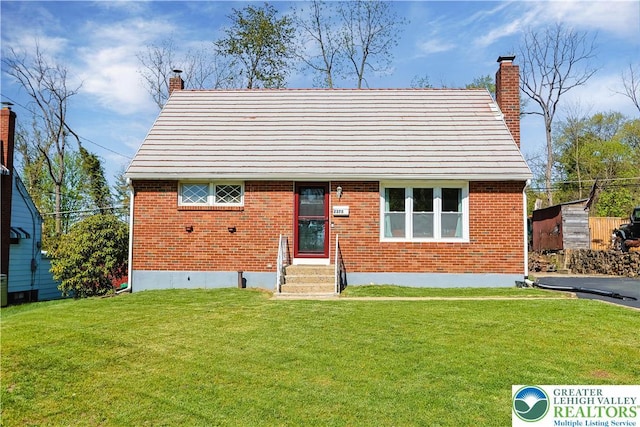 back of house with a lawn, brick siding, and a chimney