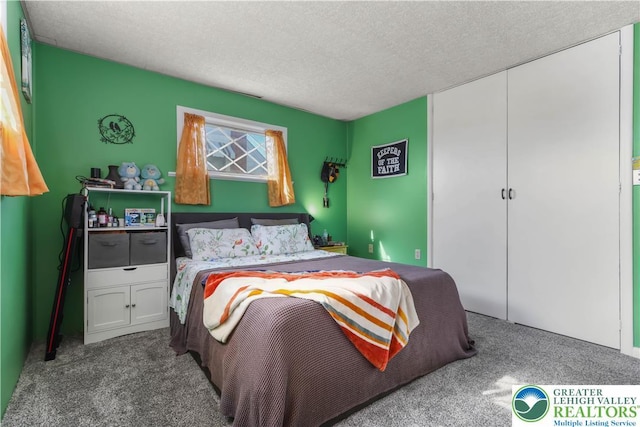 carpeted bedroom with a textured ceiling and a closet