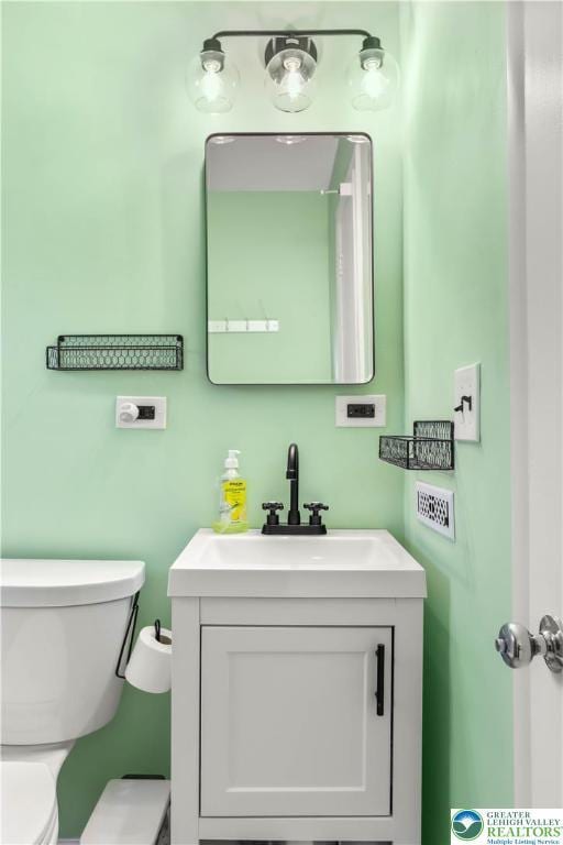 half bathroom with vanity and toilet
