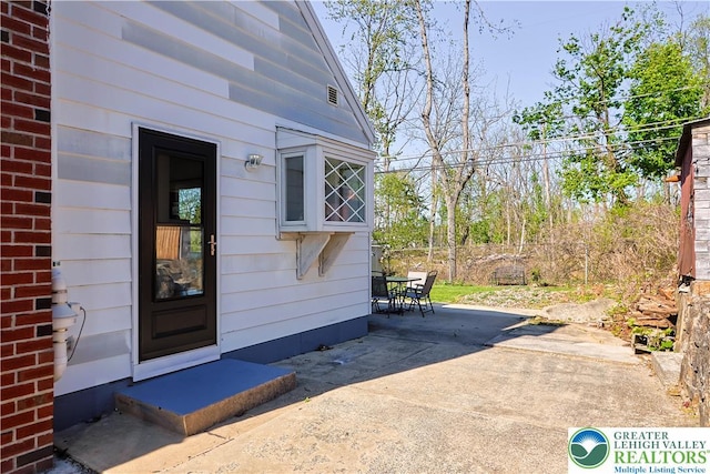 property entrance with outdoor dining space and a patio area