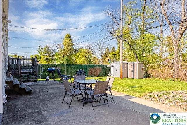 view of patio with a storage shed, outdoor dining space, an outdoor structure, and a fenced backyard