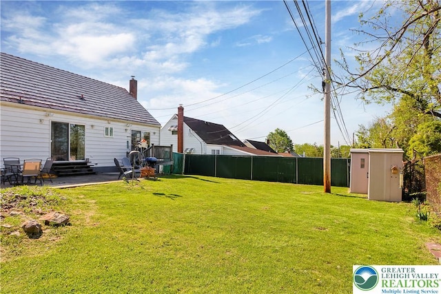 view of yard with a storage shed, a patio area, fence, an outdoor structure, and entry steps