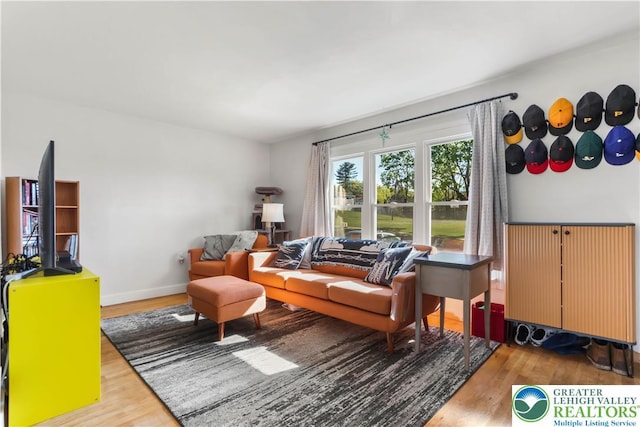 living area with baseboards and wood finished floors