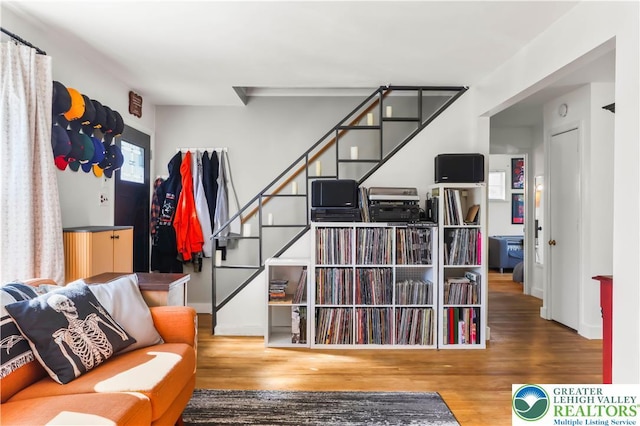 living area with stairway and wood finished floors