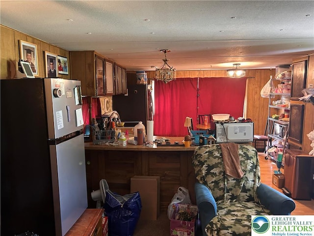 2845 Pacific Ave, North Whitehall Twp, PA 18069 - kitchen featuring freestanding refrigerator, wood walls, wood finished floors, and white microwave