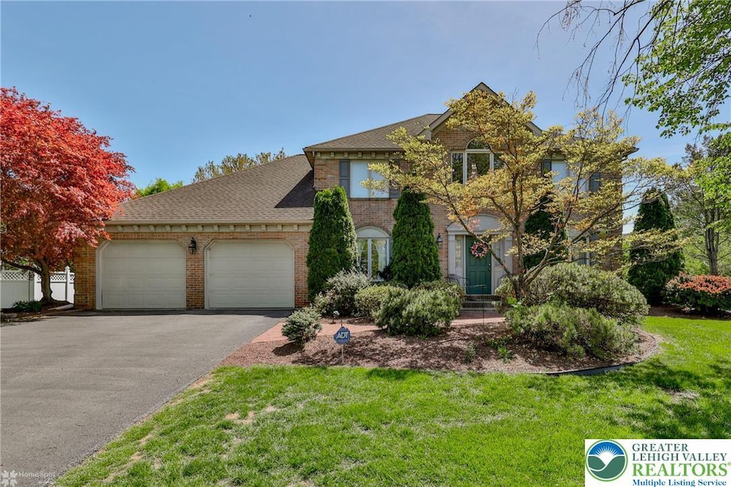 4519 Susan Dr, Hanover Twp, PA 18017 - view of front facade with an attached garage, a front lawn, aphalt driveway, and brick siding