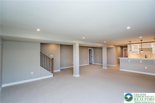 unfurnished living room with baseboards, recessed lighting, stairs, and light carpet