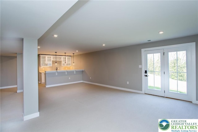 unfurnished living room featuring baseboards, light carpet, and recessed lighting
