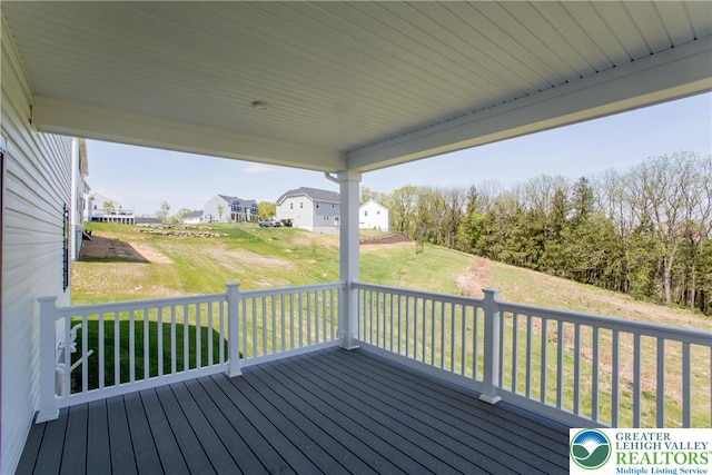 wooden deck featuring a lawn
