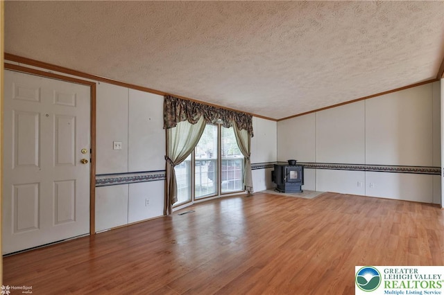unfurnished living room featuring crown molding and a textured ceiling