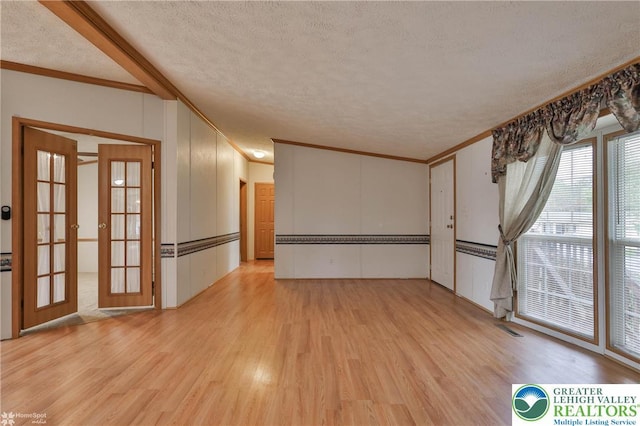 spare room featuring ornamental molding and light wood-type flooring