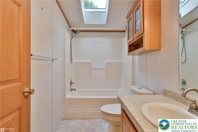 bathroom featuring vanity, shower / bathtub combination, toilet, tile patterned floors, and a skylight