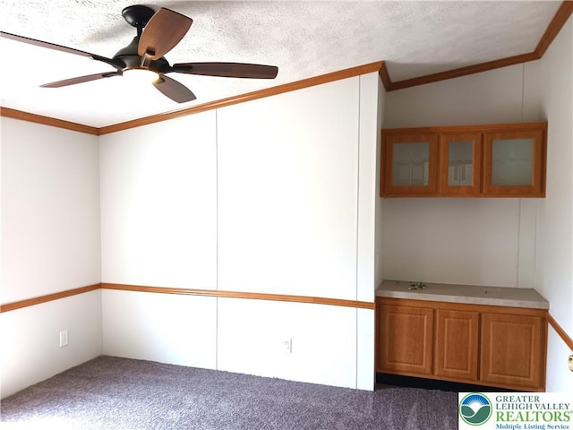 spare room featuring carpet floors, a ceiling fan, and ornamental molding