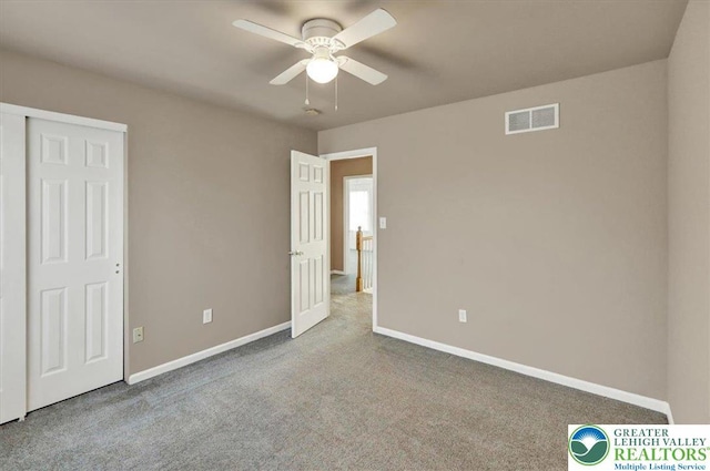 unfurnished bedroom featuring visible vents, carpet, baseboards, and a ceiling fan