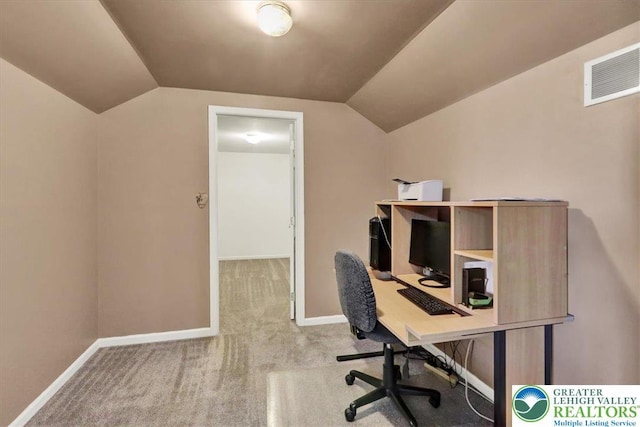 carpeted office space featuring visible vents, baseboards, and vaulted ceiling