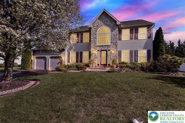 view of front of home with a front lawn, driveway, and stone siding