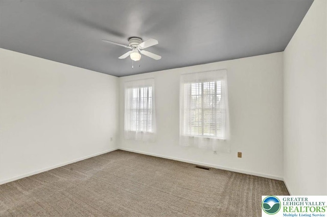 spare room featuring visible vents, carpet, ceiling fan, and baseboards