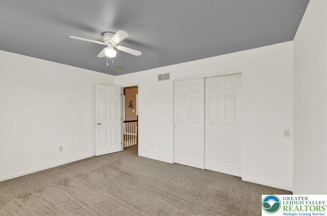 unfurnished bedroom with carpet, a ceiling fan, baseboards, visible vents, and a closet