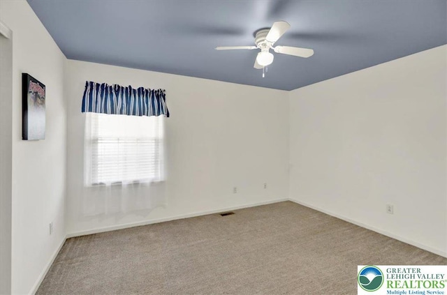 unfurnished room with ceiling fan, visible vents, baseboards, and carpet