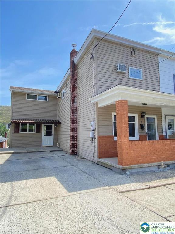 view of front of home with covered porch and brick siding
